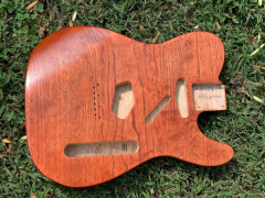 Buren's dark orange swamp ash cross-grain strat body in truoil